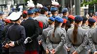 Deutsche und französische Soldaten stehen in Reihen nebeneinander beim Appell